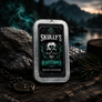 A rectangular metal tin of Skully's Heartstopper solid Cologne stands on a dark wooden surface with rocks, evergreen branches, and a smoky mountain landscape in the background. The tin has a brushed silver metal frame and a black label featuring a skull illustration with teal and white details.