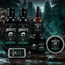 A beard grooming set from Skully's Heartstopper, including beard wash, beard conditioner, an amber dropper oil, a jar, and a tin, all featuring black and teal skull labels, arranged on a dark, moody forest background.